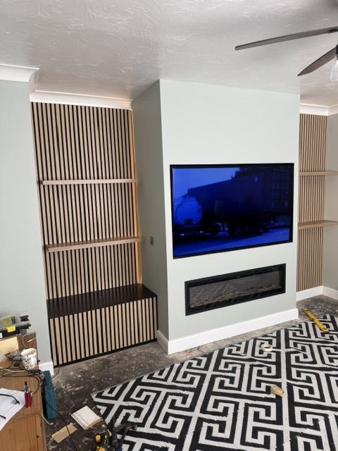 Fitted media wall with fireplace and slat panelling